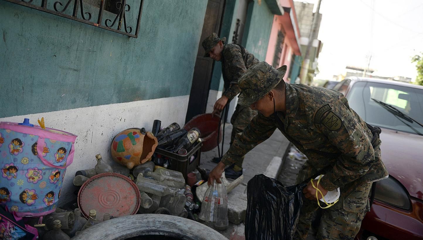 Soldiers take part in a campaign to eliminate potential breeding sites of the Aedes mosquito which transmits dengue and chikungunya, in Amatitlan, 33km south of Guatemala City, on Nov 24, 2014. -- PHOTO: AFP&nbsp;
